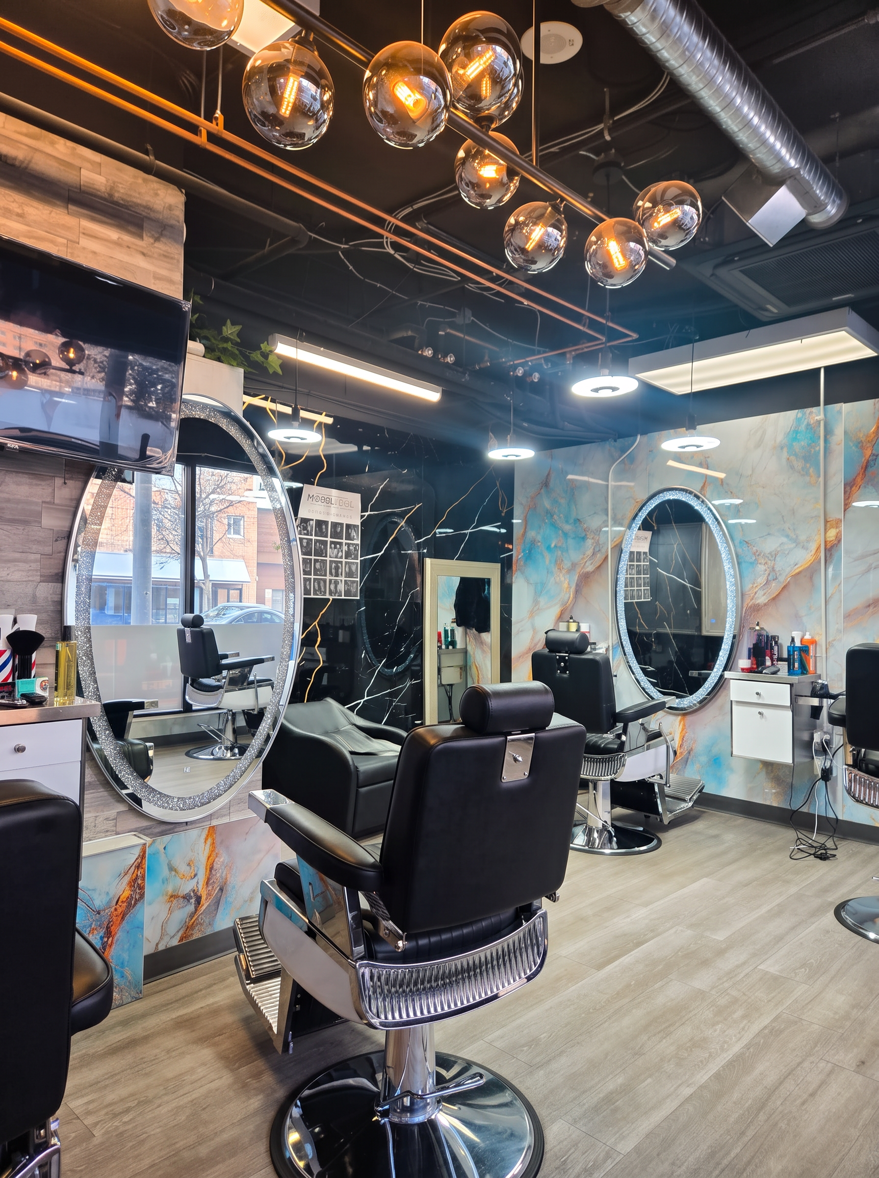 Interior of MESH salon: black marble stations, brass sconces and warm amber light